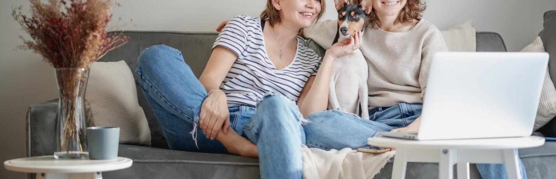 two girls and a dog sitting on couch