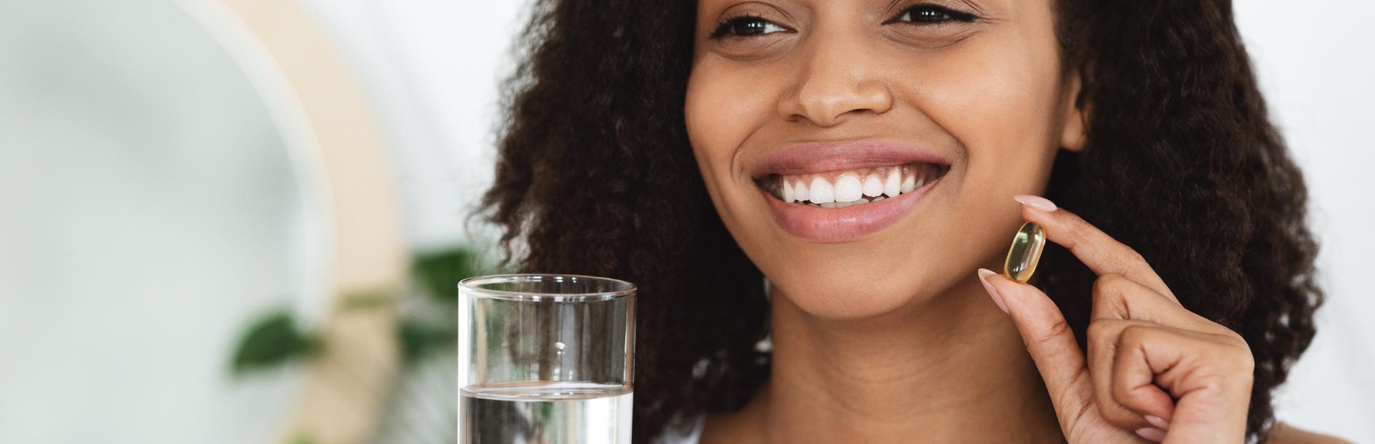 woman holding a supplement and water