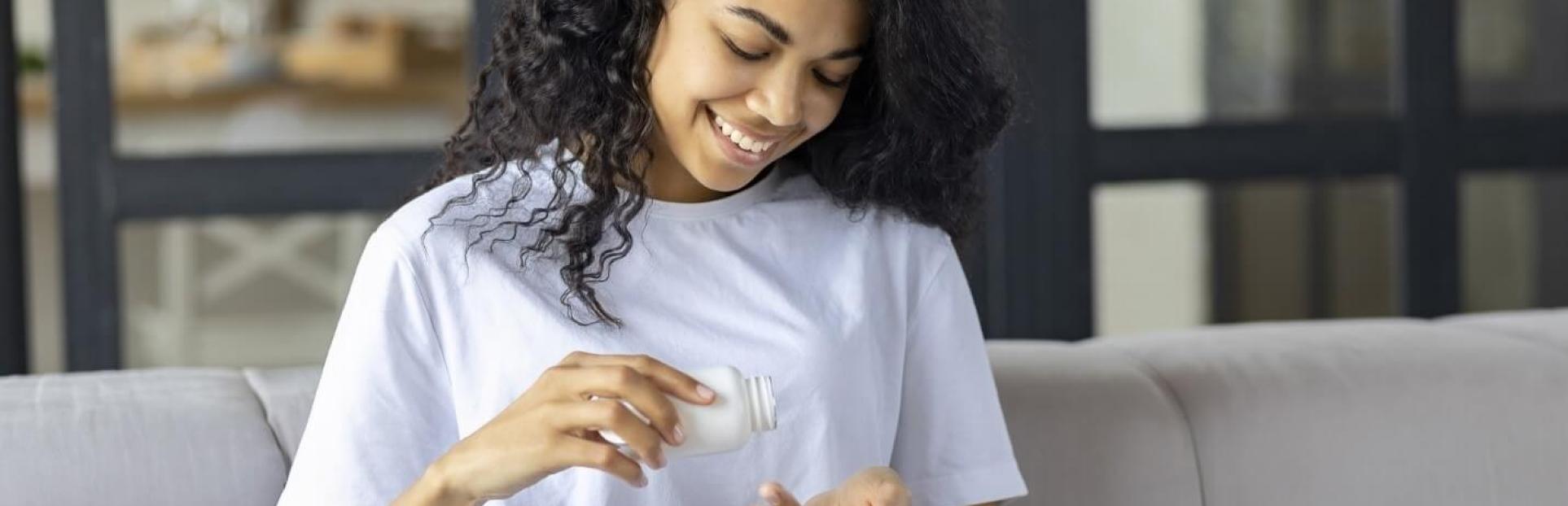 woman pouring supplements into hand