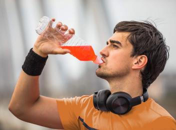 man drinking red beverage