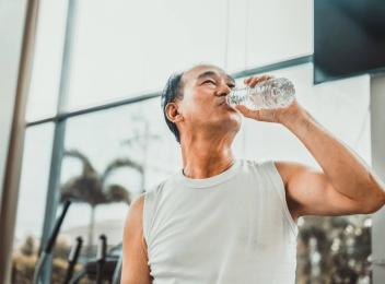 man drinking water in gym