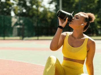 woman drinking water after workout