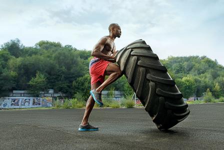 man pushing tire