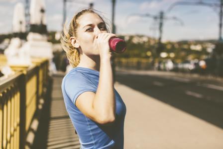 woman drinking beverage after running