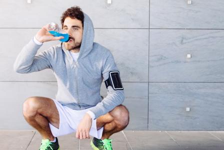 man drinking beverage after workout