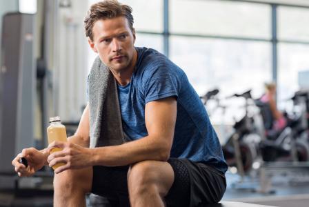 man drinking beverage after workout