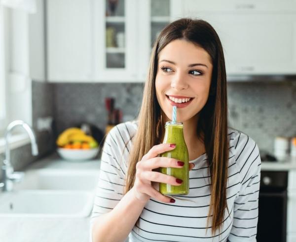 woman drinking green juice