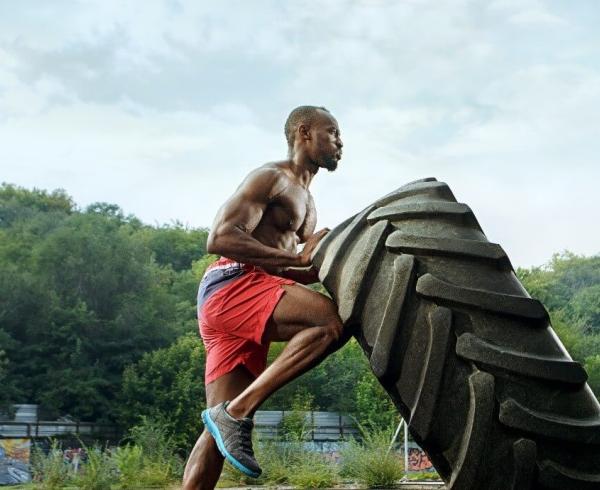 man pushing tire