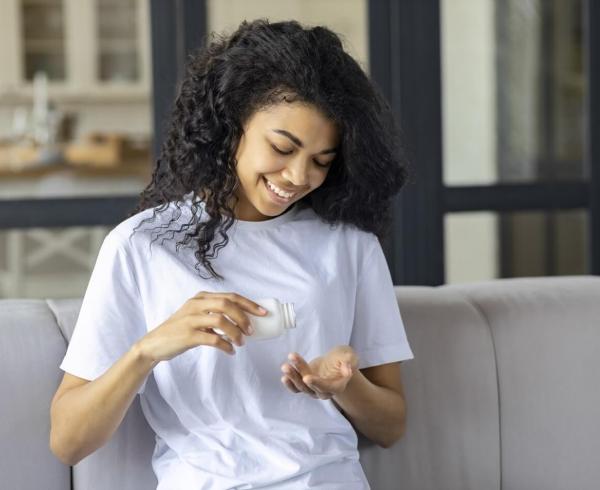 woman pouring supplements into hand