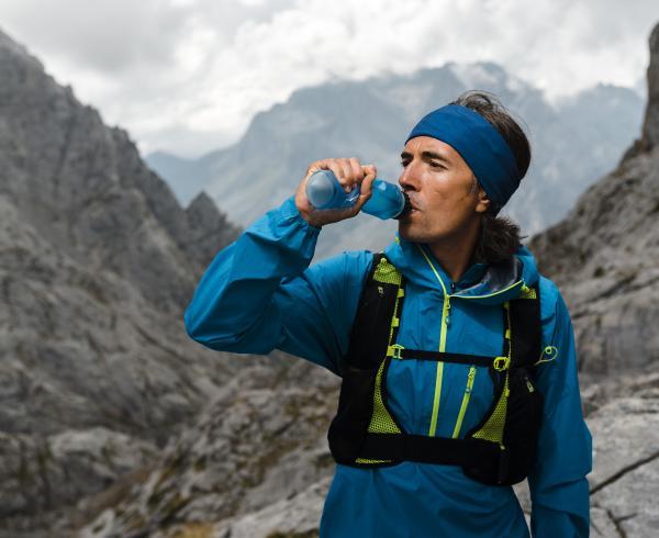 man hiking drinking beverage