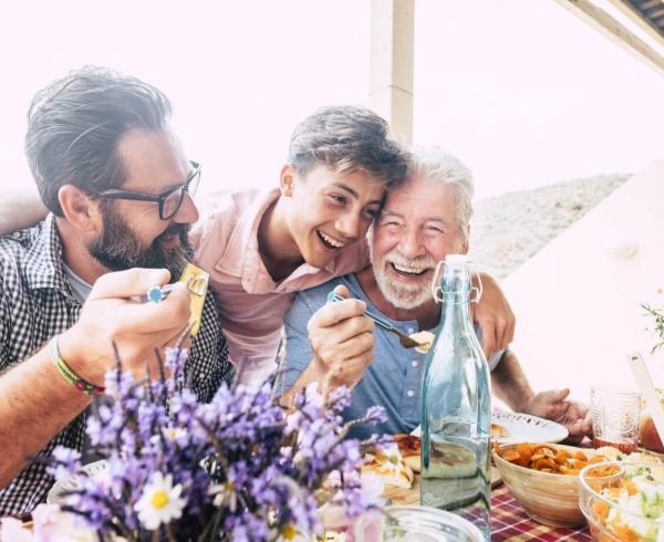 3 men laughing and eating