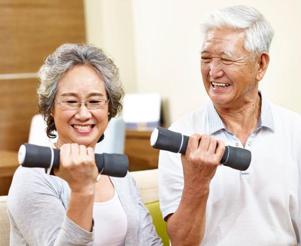 senior man and woman lifting weight