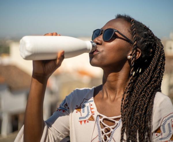 woman drinking out of water bottle