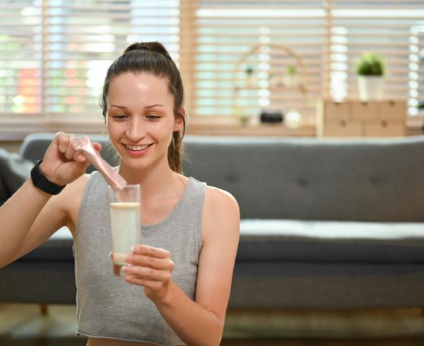 woman pouring powder mix into water
