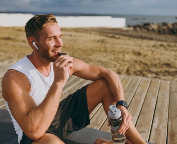 man eating a bar outside