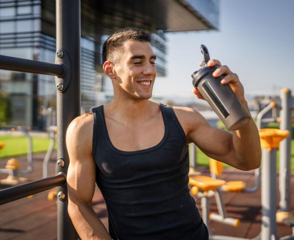 Man drinking protein shake outside
