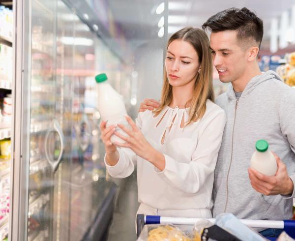 couple looking at milk in grocery store