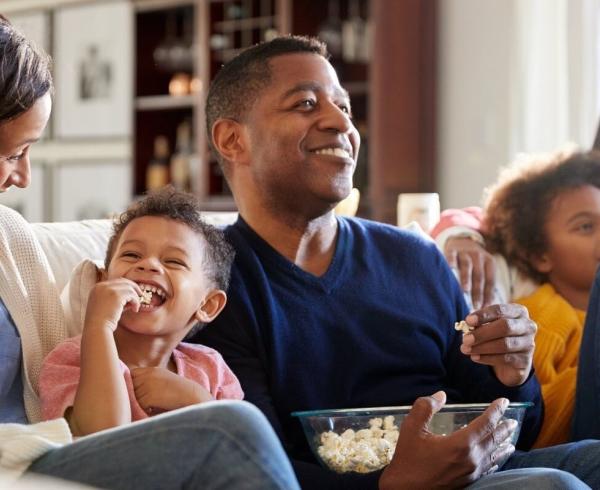 family eating popcorn on couch