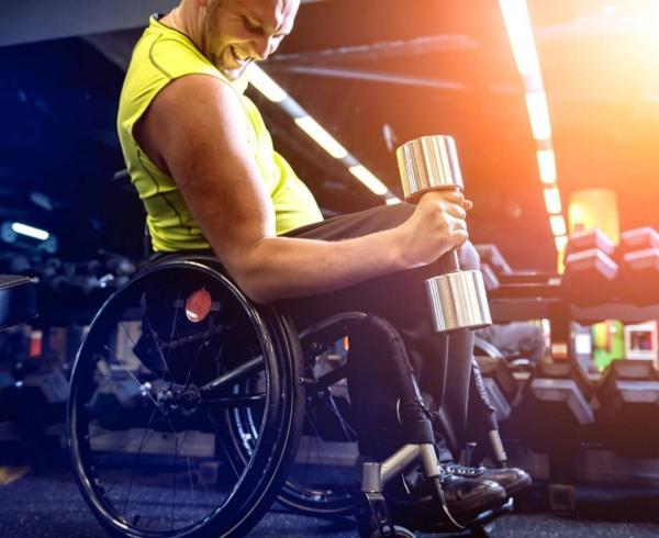 man in wheelchair lifting weight