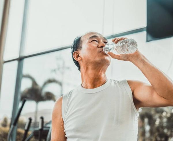 man drinking water in gym