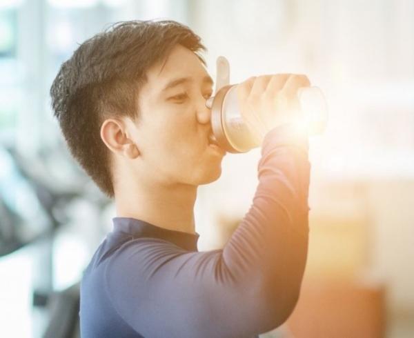 man with pre-workout beverage in gym gn