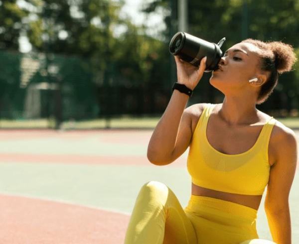 woman drinking water after workout