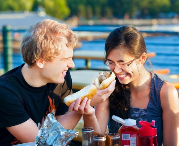 two people eating hot dogs