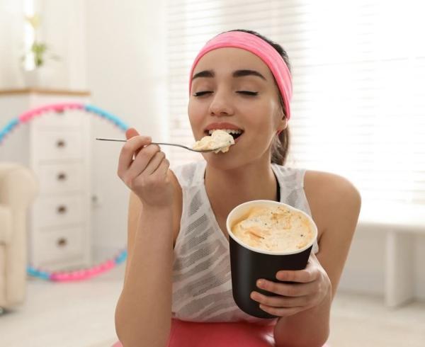 woman eating ice cream on exercise ball